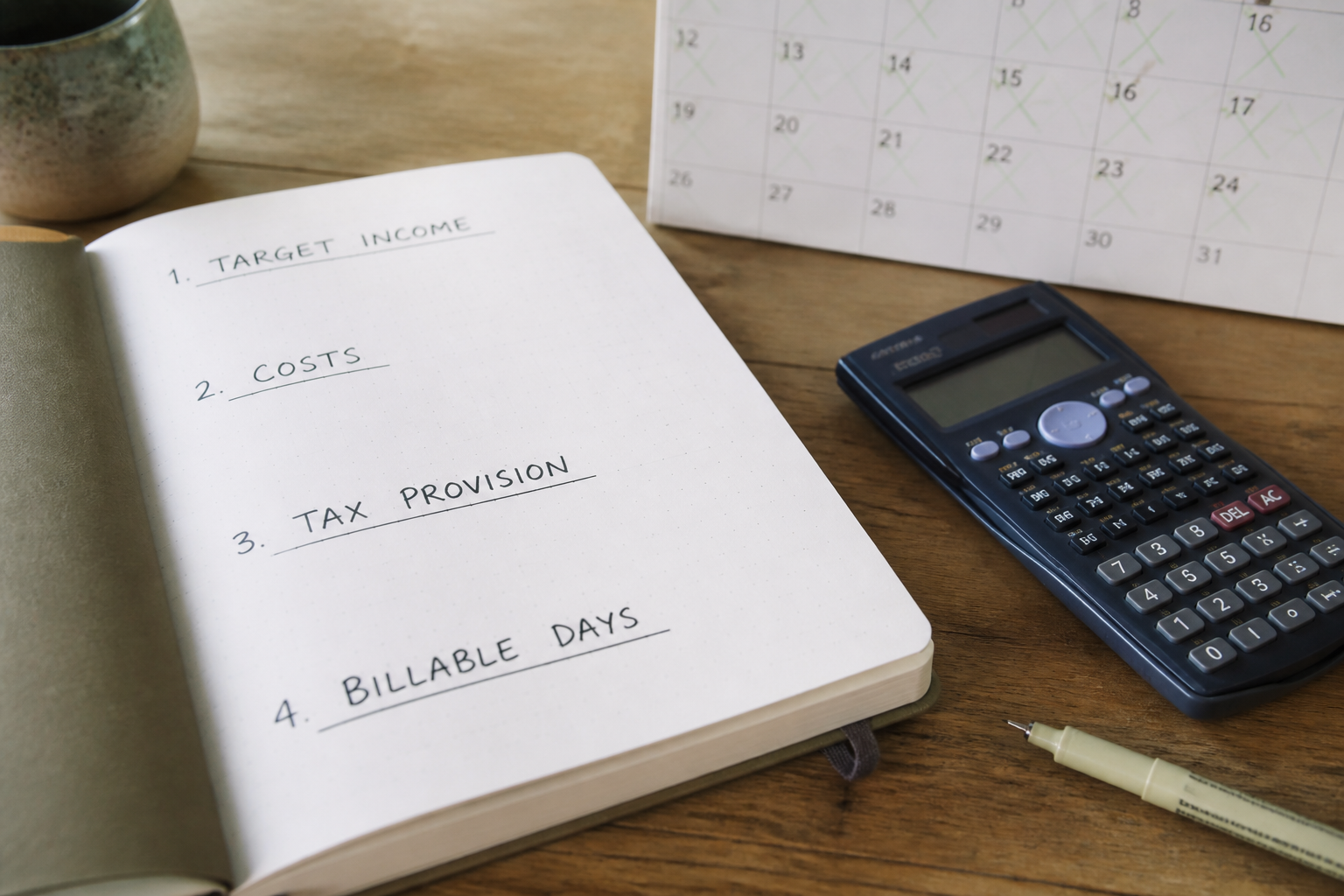 Flat lay of a pricing worksheet showing four handwritten headings, target income, costs, tax provision and billable days, next to a calculator and a wall calendar with working days ticked